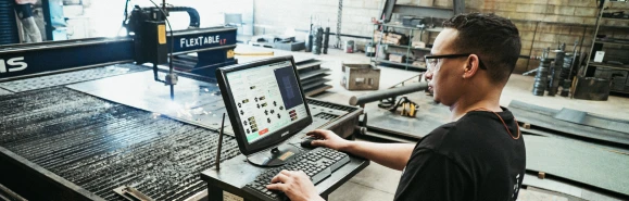 Homem programando a máquina CNC